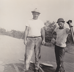 Old black-and-white photo of workers performing maintenance on a commercial rooftop