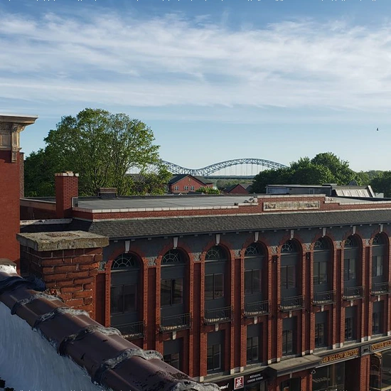 Rooftop view of a brick building with an arched bridge in the distance